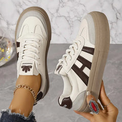 Elegant women's striped flowy sneakers by Christine Brewer featuring a stylish casual design and comfortable fit.