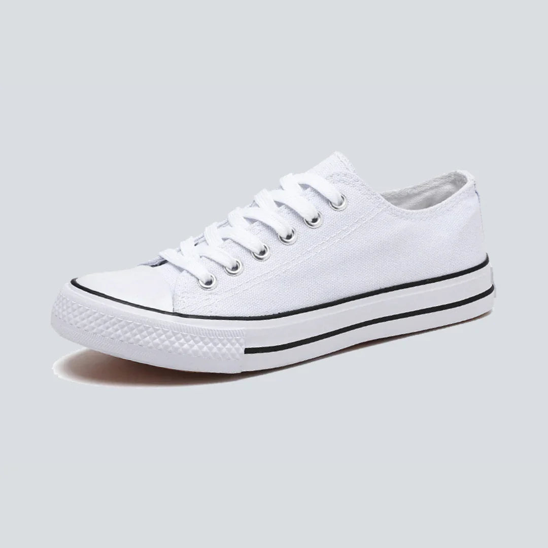 Comfortable women's low-top canvas sneakers by Christine Brewer, featuring a casual design and white laces on a white background.