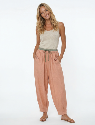 Loose tapered linen trousers for women by Christine Brewer, featuring a relaxed fit and pull-on style in natural linen fabric.