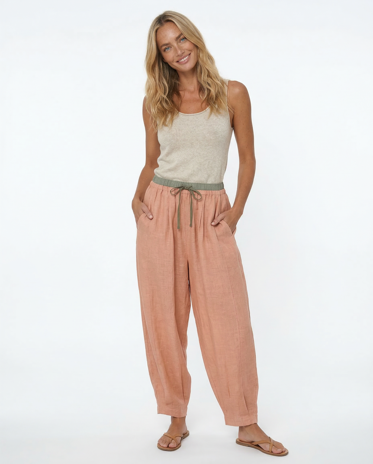 Loose tapered linen trousers for women by Christine Brewer, featuring a relaxed fit and pull-on style in natural linen fabric.