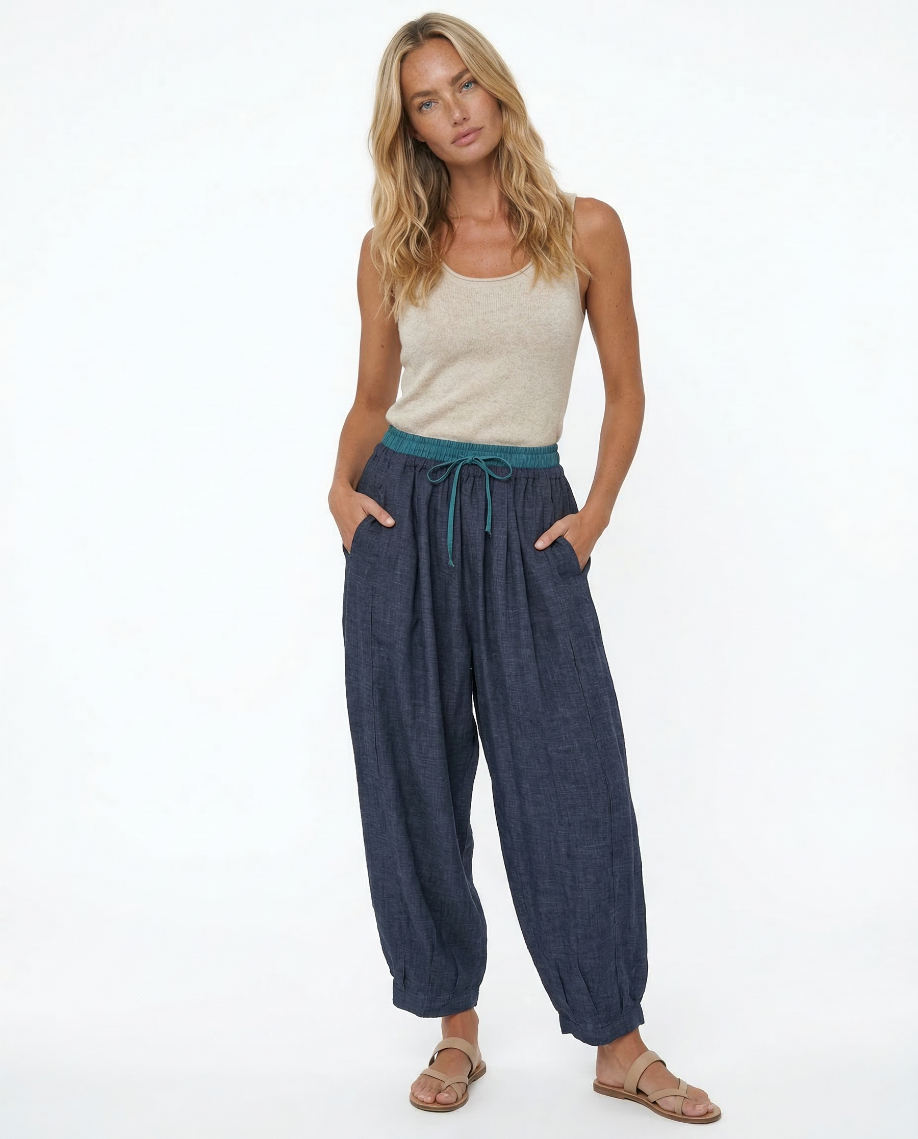 Loose tapered linen trousers for women by Christine Brewer, featuring a relaxed fit and pull-on style in natural linen fabric.