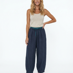 Light beige tapered linen trousers for women, loose pull-on style from Christine Brewer, displayed on a model.