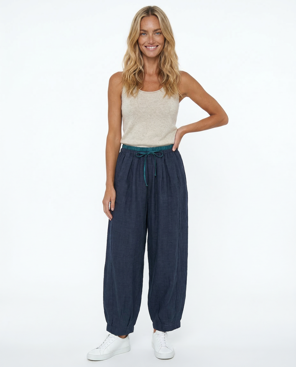 Light beige tapered linen trousers for women, loose pull-on style from Christine Brewer, displayed on a model.