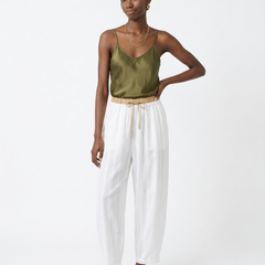 Cream-colored tapered linen trousers for women with a loose fit and pull-on style, designed by Christine Brewer.