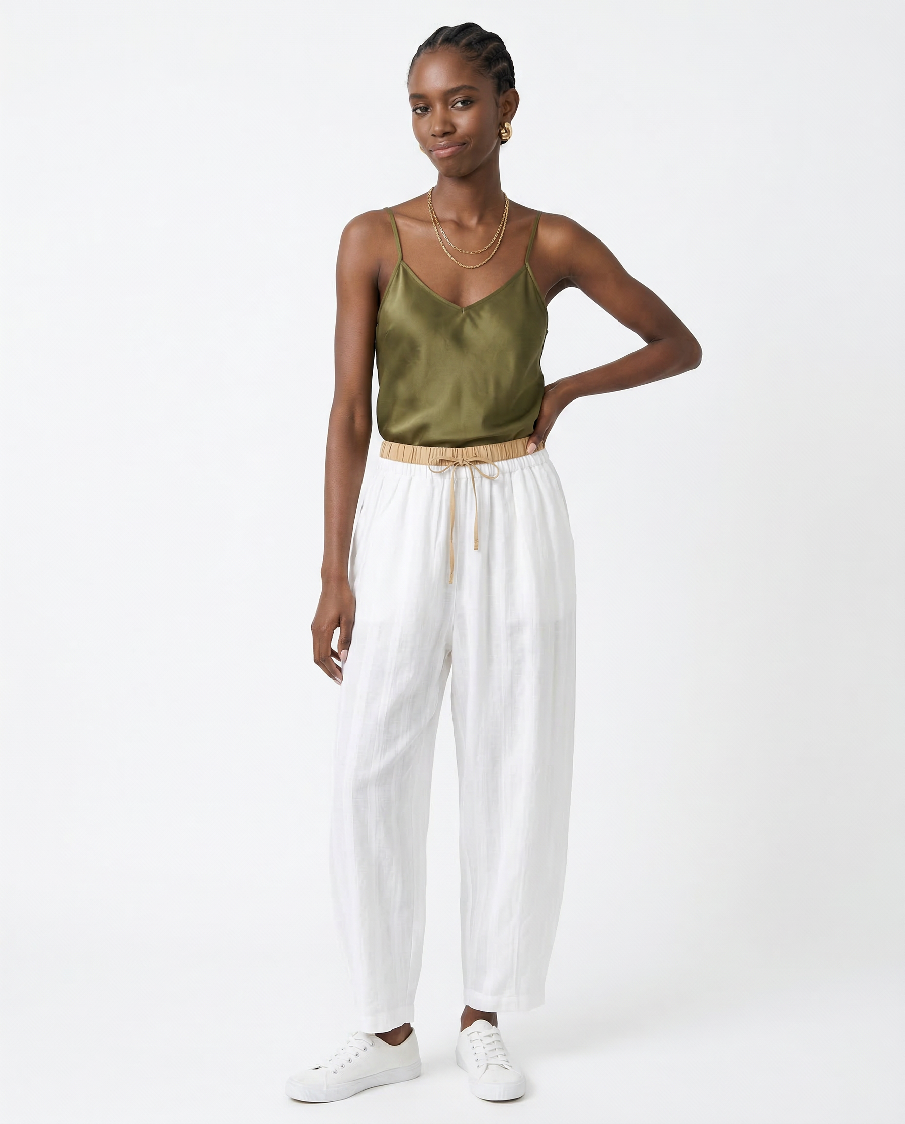 Cream-colored tapered linen trousers for women with a loose fit and pull-on style, designed by Christine Brewer.