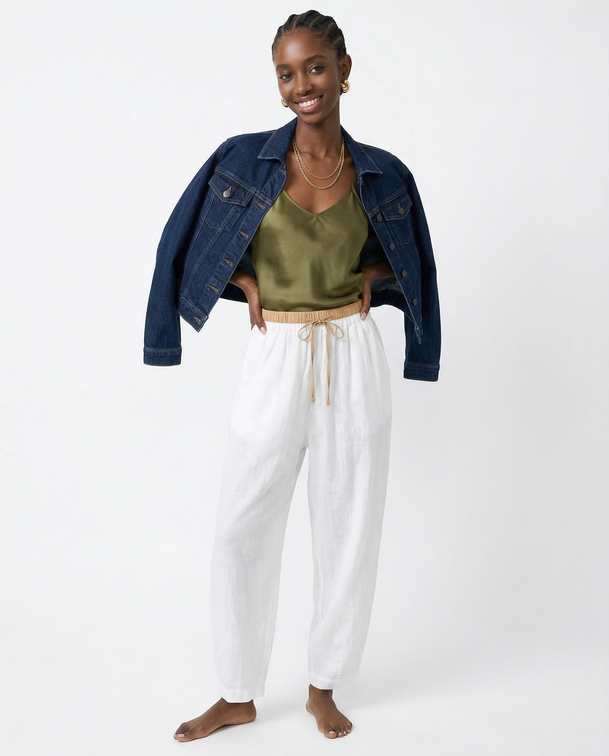 Light beige tapered linen trousers for women by Christine Brewer, featuring a loose, pull-on design and relaxed fit.