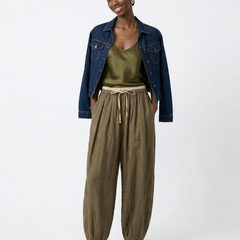 Women’s tapered linen trousers by Christine Brewer featuring a loose fit and pull-on design, shown in a neutral color.