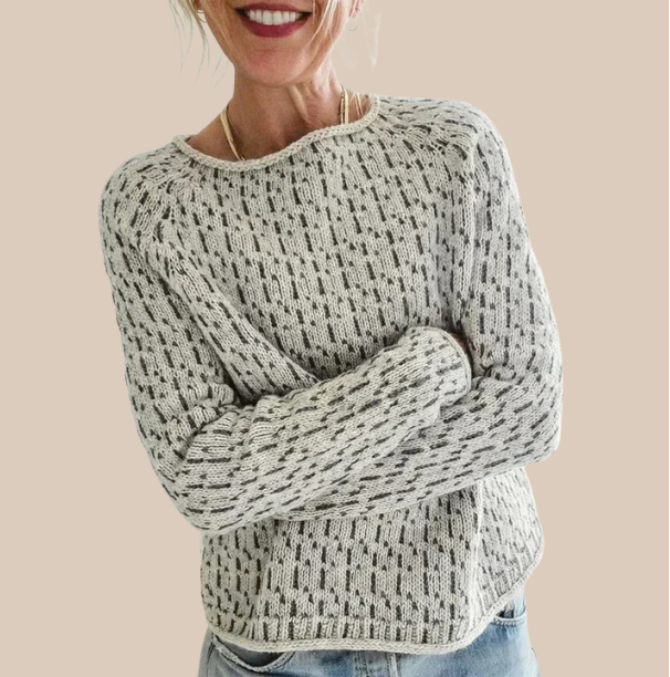Woman wearing a cozy knit sweater from Christine Brewer's Penelope collection, featuring a soft, stylish design.