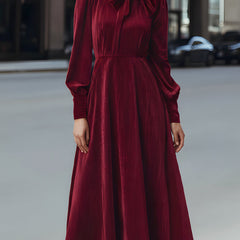 Burgundy velvet pleated bow-neck midi dress by Christine Brewer, elegant cocktail dress with a fitted waist and flowing skirt.