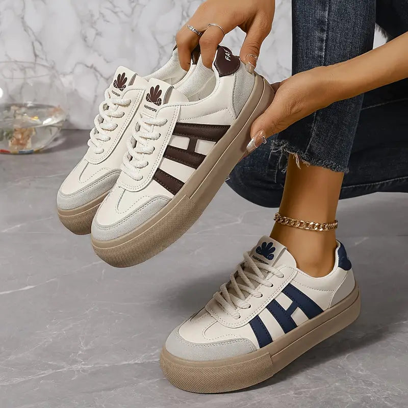 Elegant women's striped flowy sneakers by Christine Brewer, featuring stylish design and comfortable fit, shown on a white background.