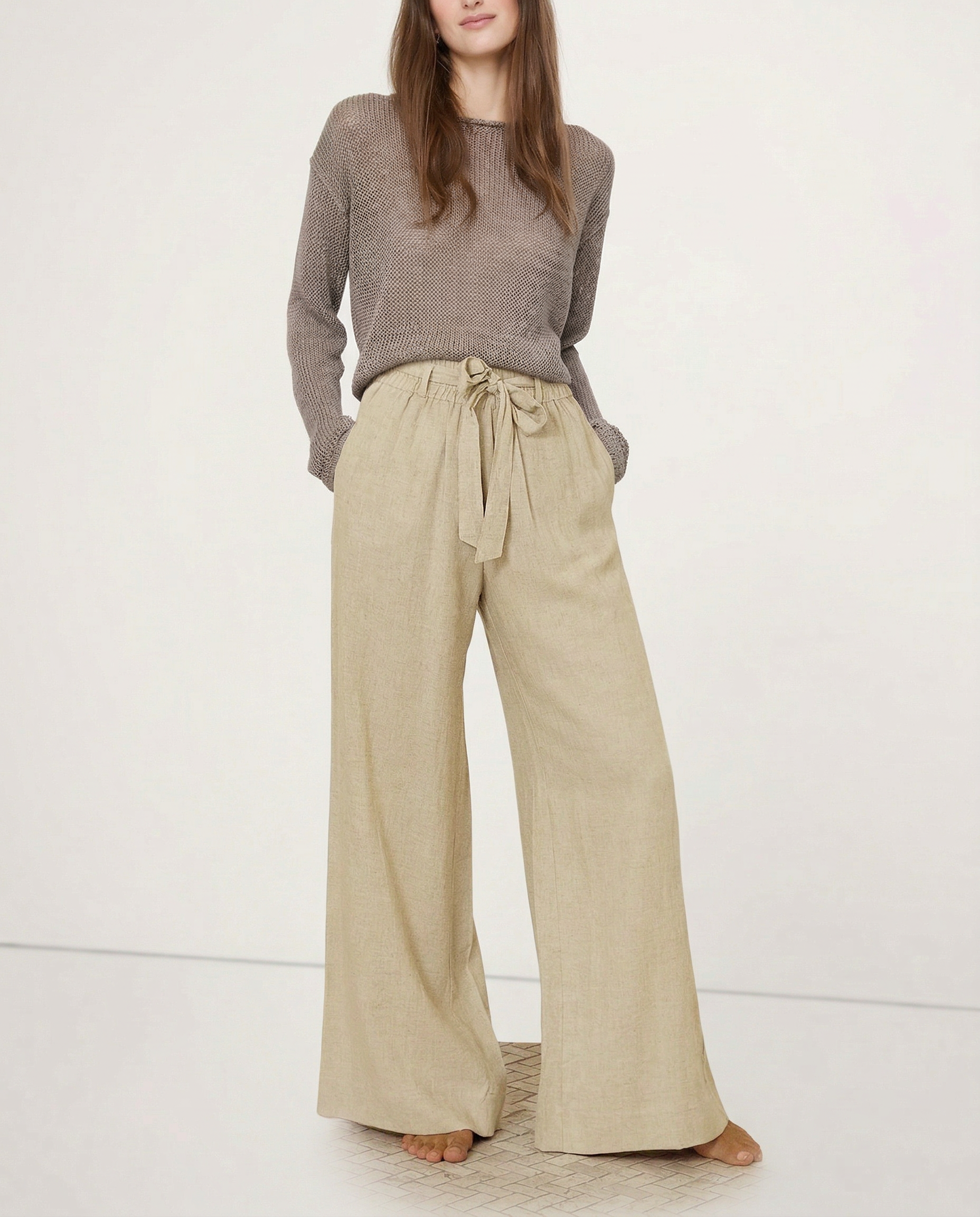 Light beige linen wide-leg trousers for women by Christine Brewer, featuring a loose pull-on style and visible fabric texture.