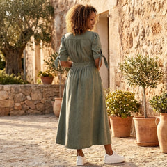 Button front midi dress by Christine Brewer with V-neckline and waist tie, shown on a model in a stylish, flowy design.