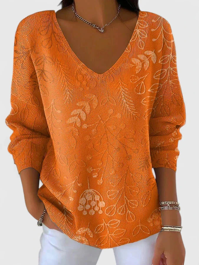 Christine Brewer Carol graphic v-neck top for women, featuring a stylish design and comfortable fit, shown in a vibrant, patterned fabric.