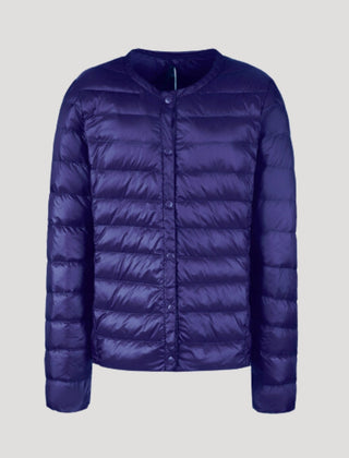 Lightweight blue quilted puffer jacket for women by Christine Brewer, featuring a cozy, stylish design with a high collar and quilted pattern.