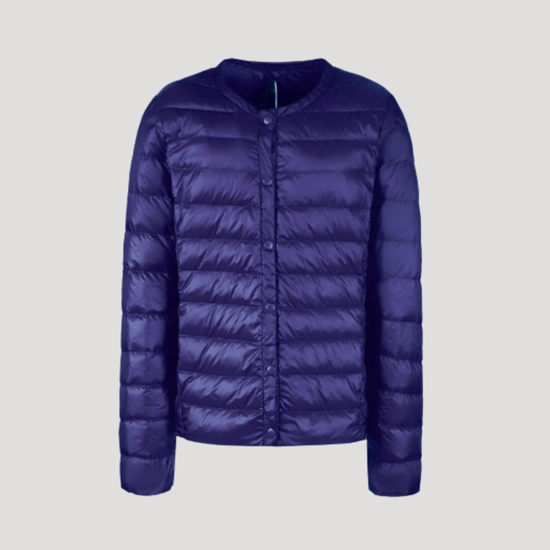 Lightweight blue quilted puffer jacket for women by Christine Brewer, featuring a cozy, stylish design with a high collar and quilted pattern.