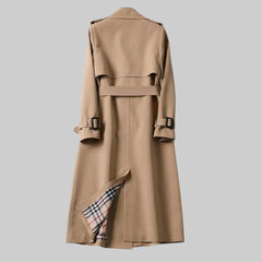 Women’s belted double-breasted long trench coat by Christine Brewer, shown in Jakarta style with classic design and belt detail.
