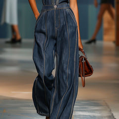 Dark blue denim women’s sleeveless v-neck jumpsuit with wide-leg pants, by Christine Brewer, shown on a model.