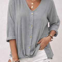 Grey women's V-neck button-front blouse from Christine Brewer's Aria collection, shown on a hanger.