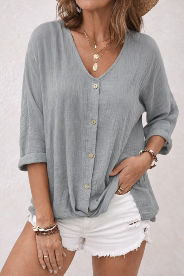 Grey women's V-neck button-front blouse from Christine Brewer's Aria collection, shown on a hanger.