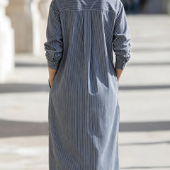 Woman wearing a stylish midi dress by Christine Brewer, featuring a fitted bodice and flowing skirt for a chic look.