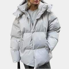 Lightly quilted Sienna long hooded puffer jacket for women by Christine Brewer, featuring a cozy hood and warm insulation.