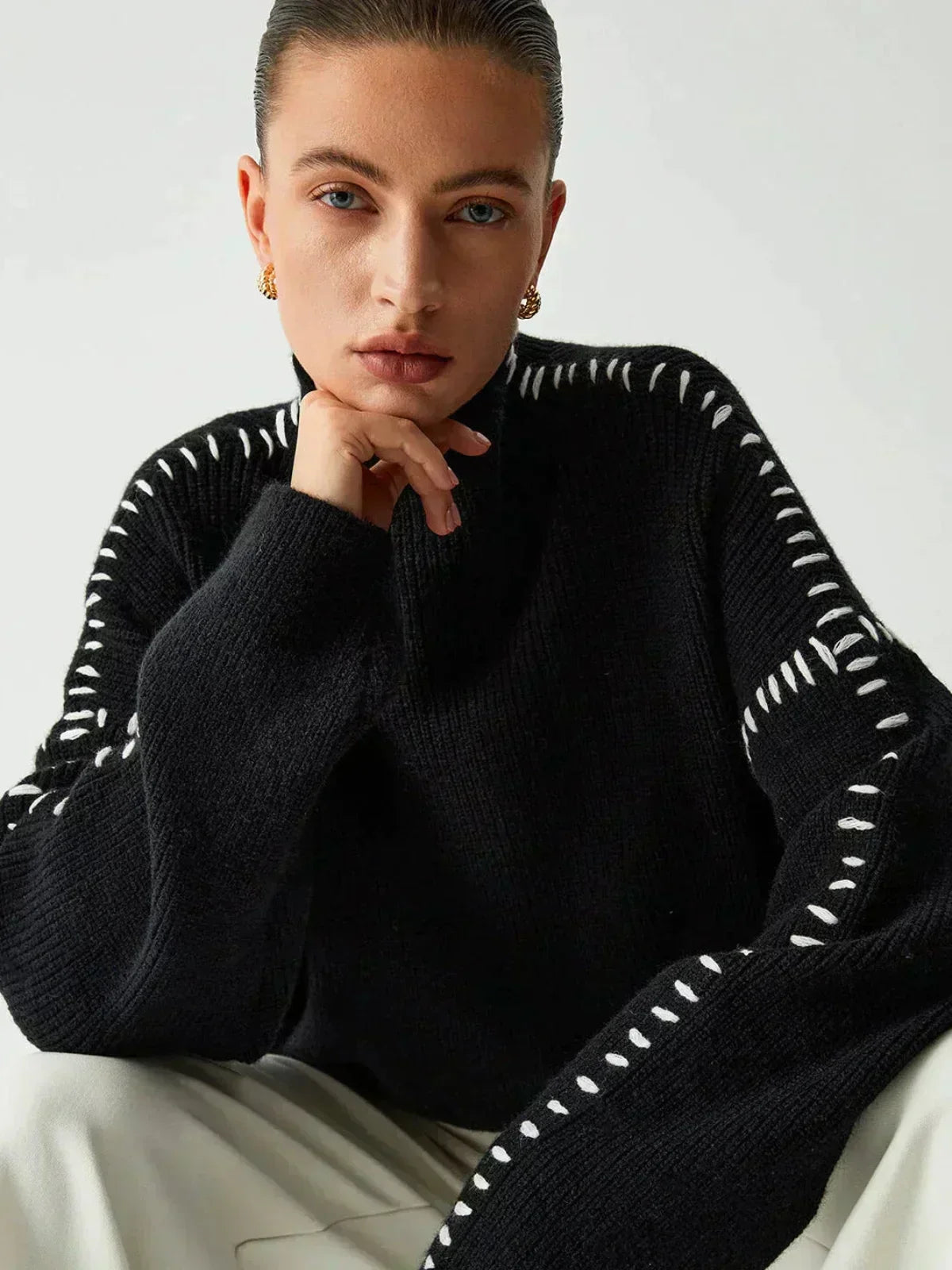 Black ribbed wool mock neck sweater by Christine Brewer, featuring whipstitch details, styled as a versatile oversized autumn sweater.