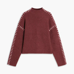 Red ribbed wool mock neck sweater by Christine Brewer featuring whipstitch details, oversized and tailored for autumn wear.