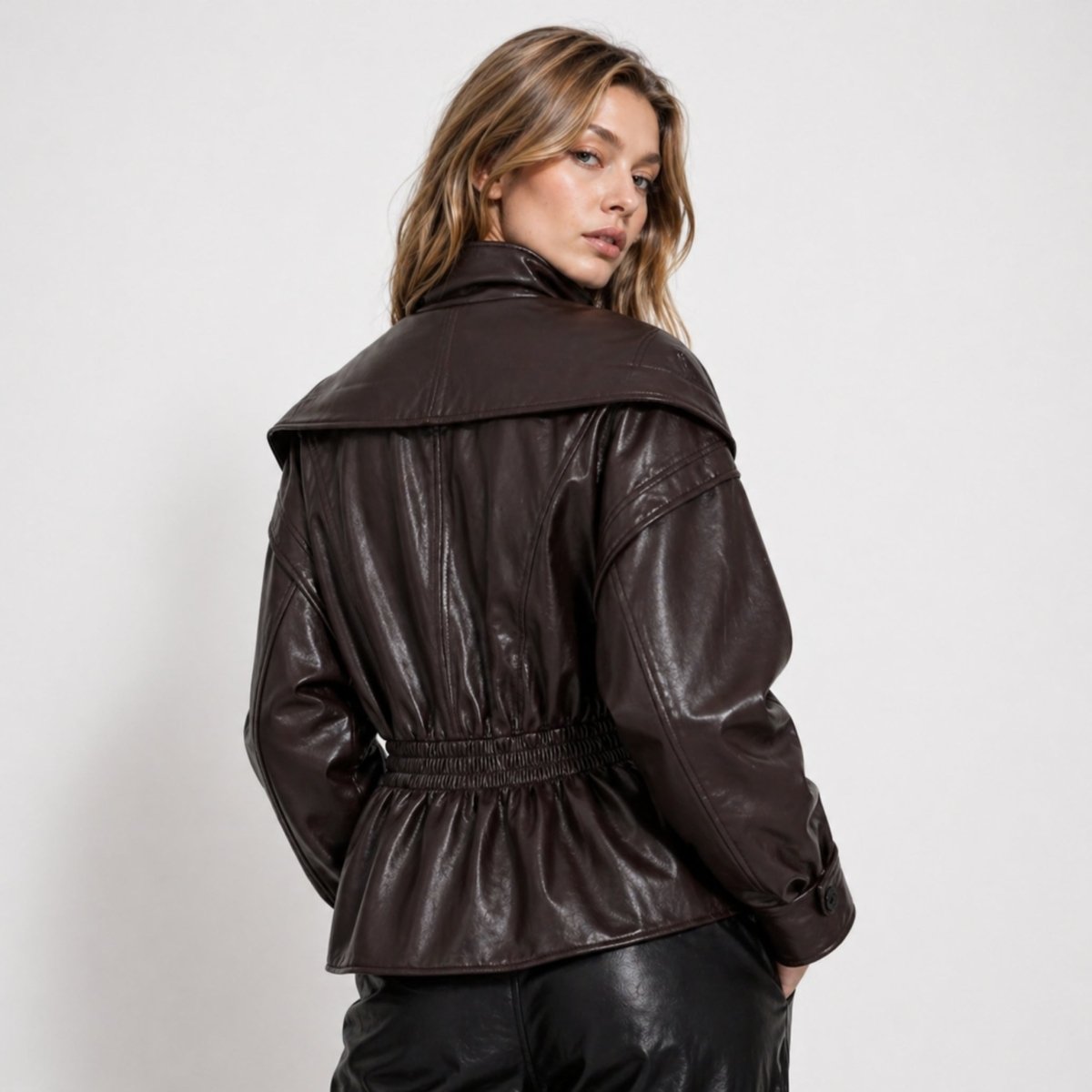 Man wearing the Lucy faux leather jacket for women by Christine Brewer, featuring a sleek design and cinched waist.