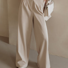 White wide-leg high-waist women's trousers by Christine Brewer, shown on a model, featuring a relaxed fit and tailored design.