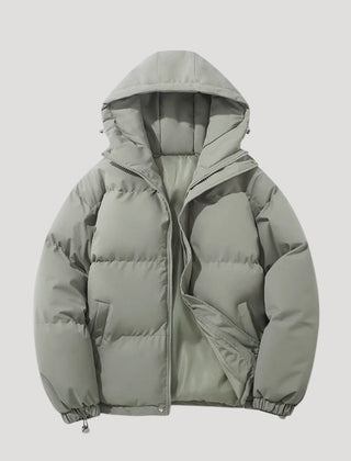 Green Evelyn hooded puffer jacket for women by Christine Brewer, insulated with a cozy hood and quilted design.