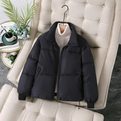 Black quilted puffer jacket for women by Christine Brewer, featuring a stylish, padded design perfect for cold weather.
