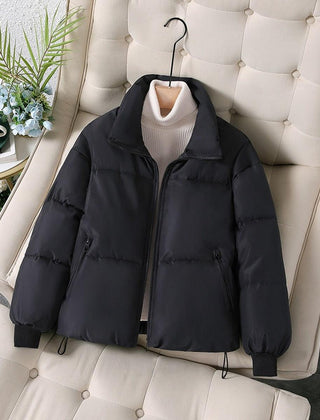 Black quilted puffer jacket for women by Christine Brewer, featuring a stylish, padded design perfect for cold weather.
