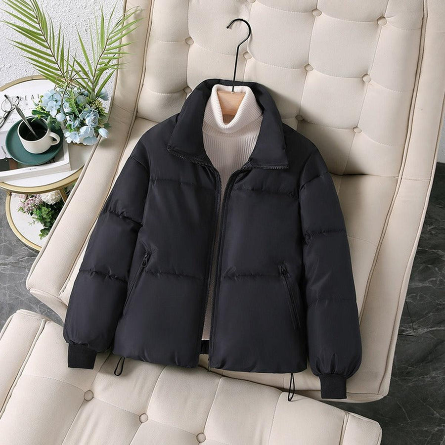 Black quilted puffer jacket for women by Christine Brewer, featuring a stylish, padded design perfect for cold weather.