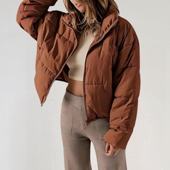 Brown Emma high collar puffer jacket for women by Christine Brewer, showcasing a cozy, insulated winter jacket with a high collar.