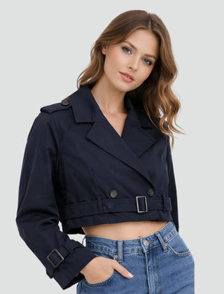 Women's cropped double-breasted trench coat by Christine Brewer, belted design, shown on a model in a neutral setting.