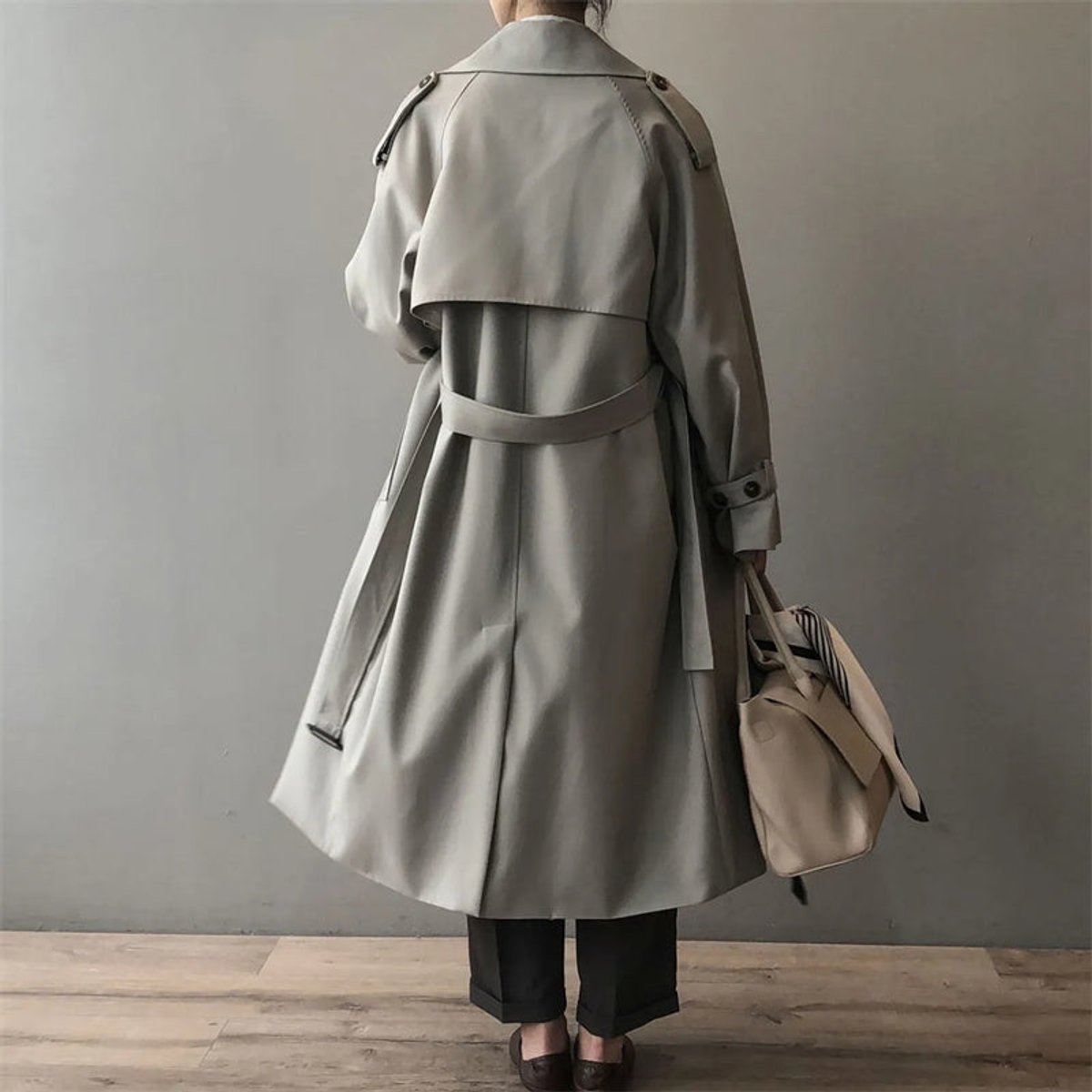 Women's double-breasted water-repellent long trench coat by Christine Brewer, shown in a stylish, water-resistant exterior.