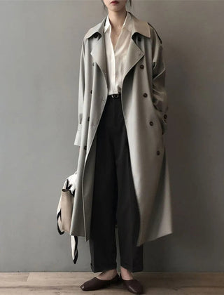 Women’s double-breasted water-repellent long trench coat by Christine Brewer, shown in a stylish, sleek design with a belt and collar.