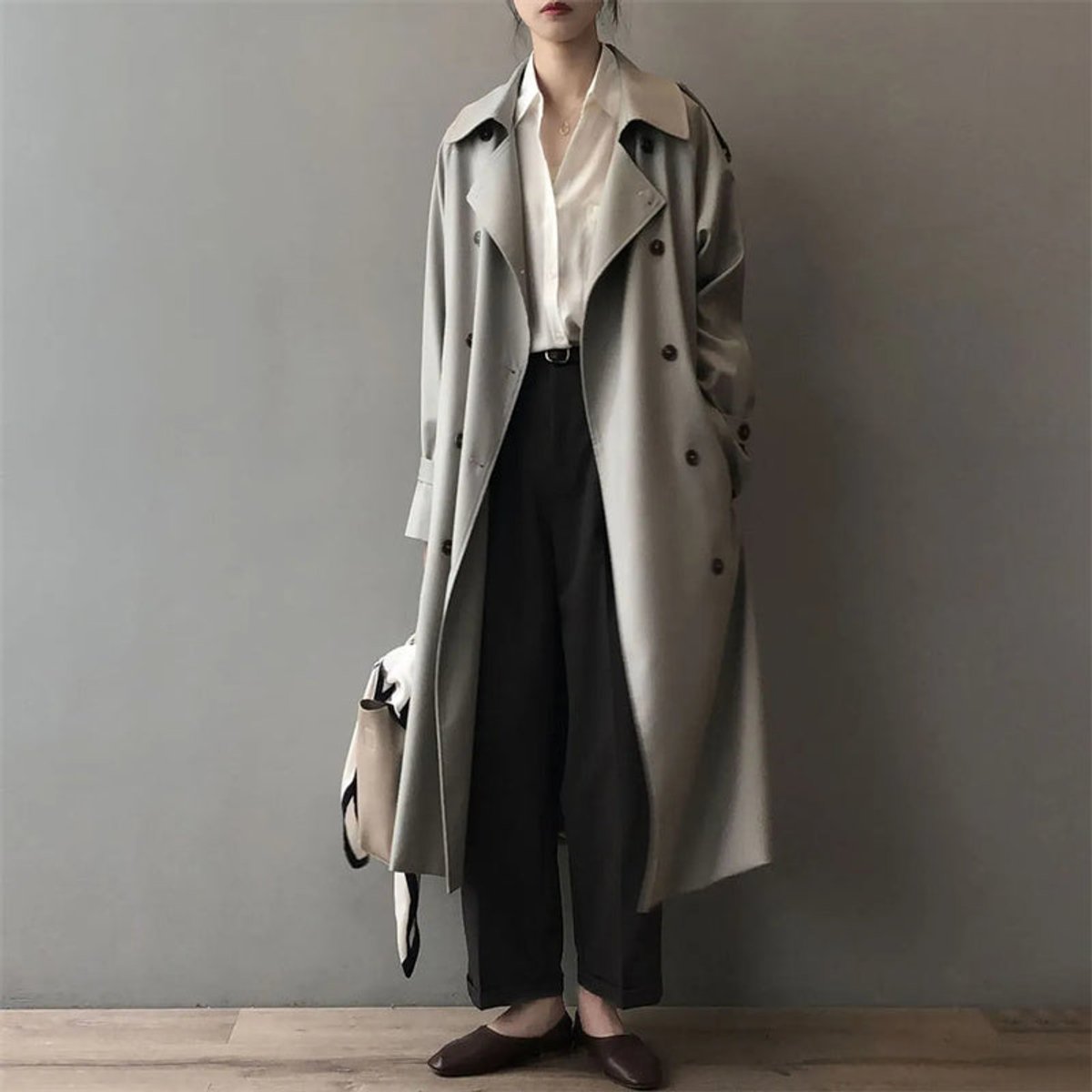 Women’s double-breasted water-repellent long trench coat by Christine Brewer, shown in a stylish, sleek design with a belt and collar.