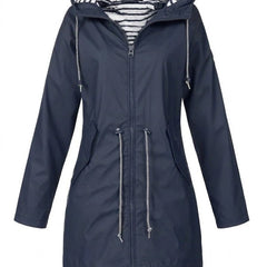 Victoria women's waterproof hooded rain coat with drawstring, by Christine Brewer, shown in a stylish outdoor setting.