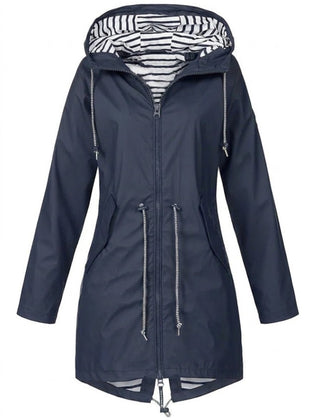 Victoria women's waterproof hooded rain coat with drawstring, by Christine Brewer, shown in a stylish outdoor setting.