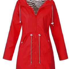 Woman wearing Christine Brewer Victoria waterproof rain coat with hood and drawstring, designed for rainy weather.