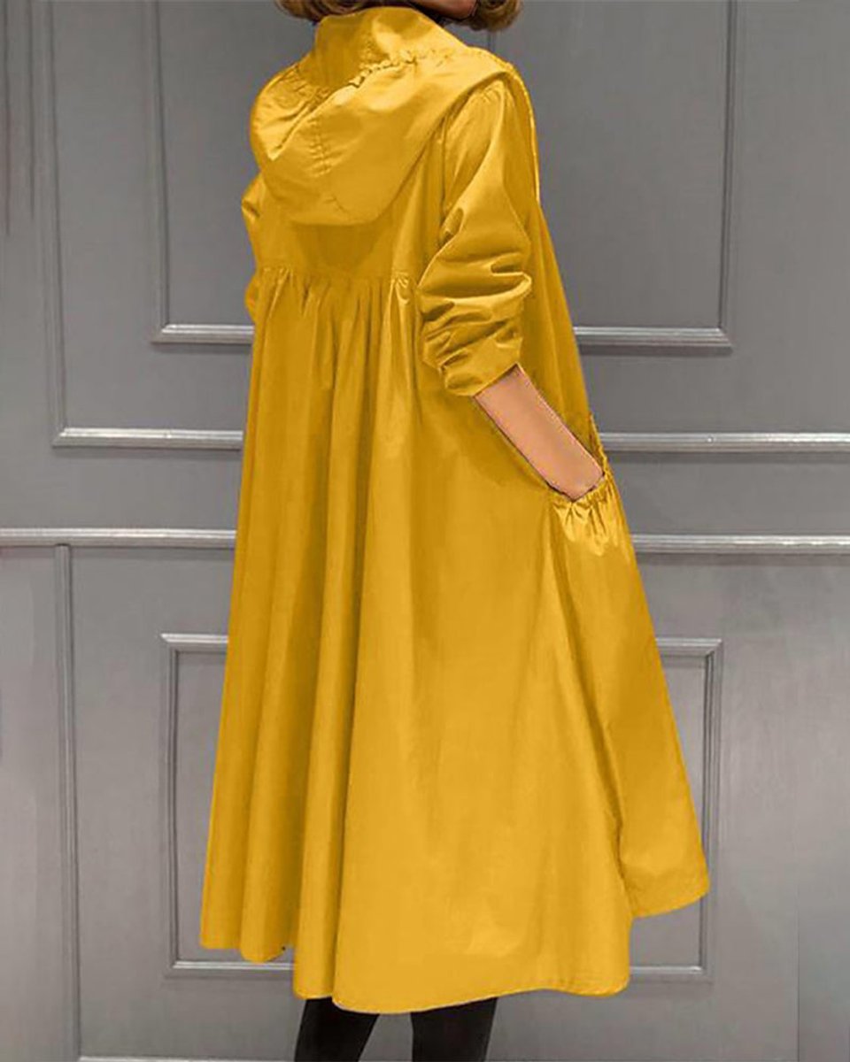 Women’s hooded waterproof longline trench coat by Christine Brewer, shown in a stylish outdoor setting.