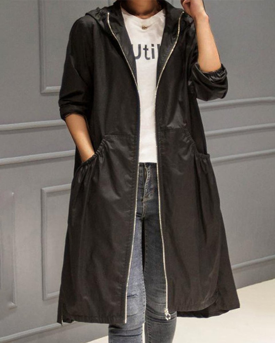 Women’s Scarlett waterproof longline trench coat with hood, stylish and rainproof, by Christine Brewer, shown on a model outdoors.