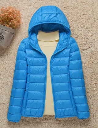 Woman wearing Christine Brewer Sienna lightweight hooded quilted jacket, packable down puffer with a hood and quilted design.