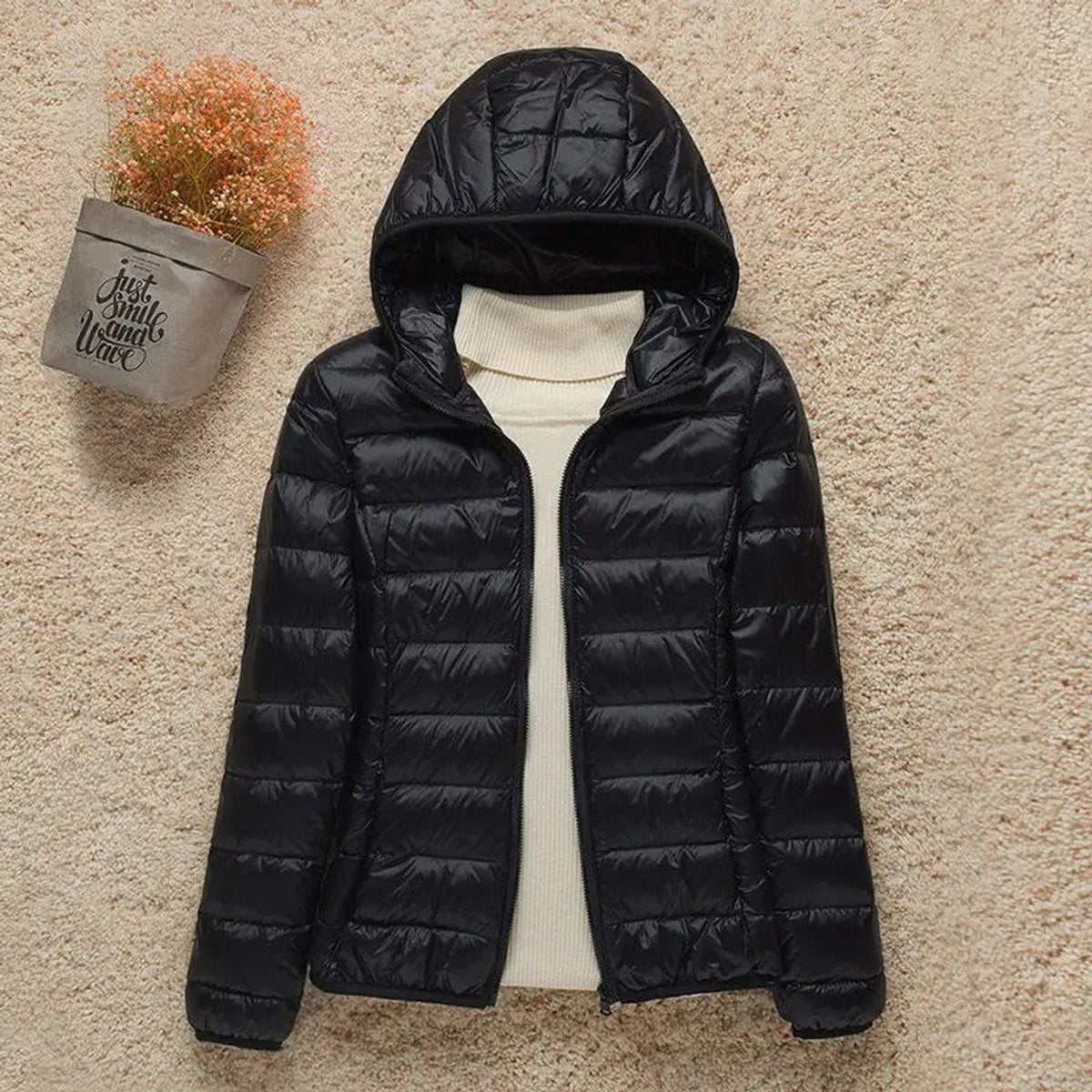 Women's lightweight hooded quilted puffer jacket by Christine Brewer, shown in a packable design with a hood and quilted texture.