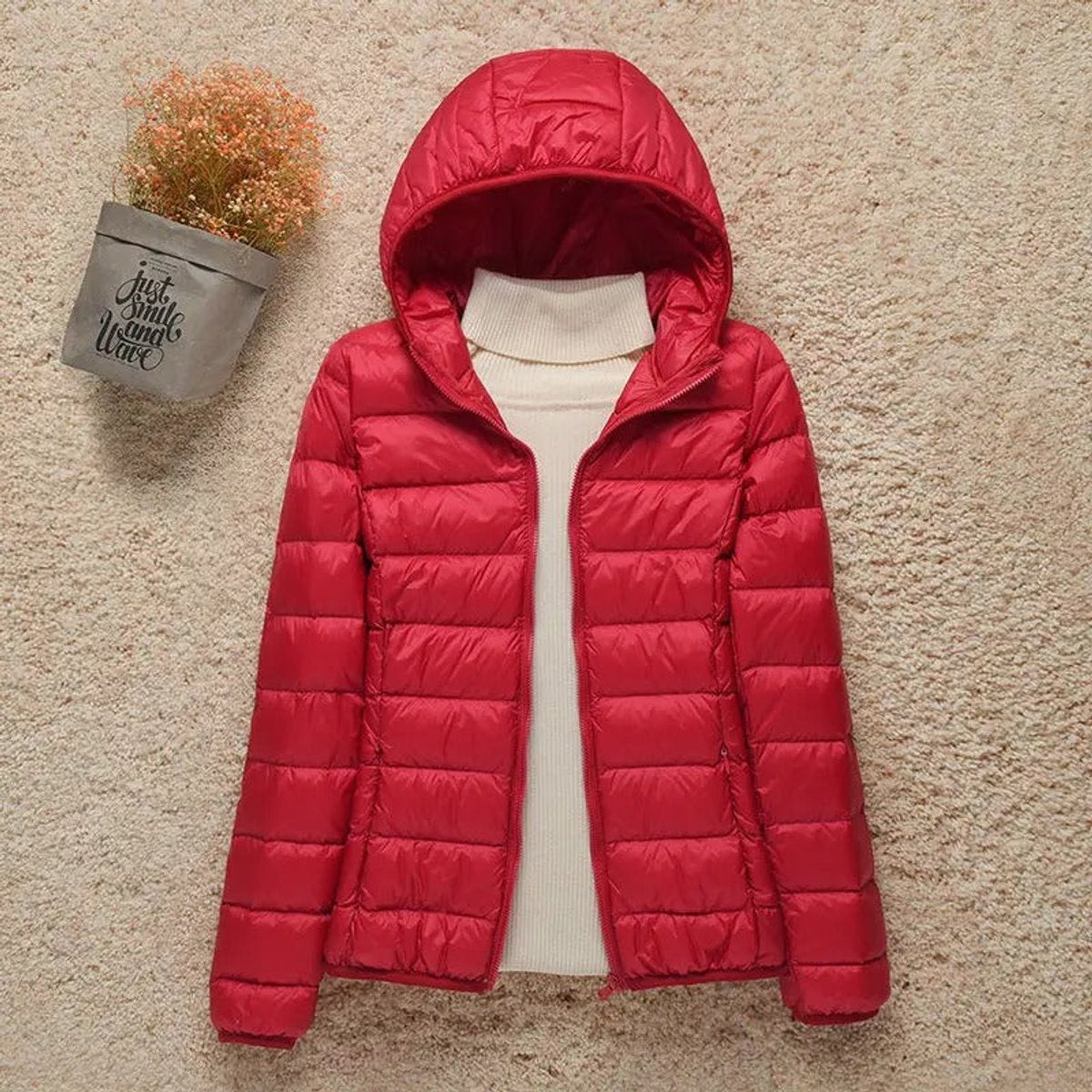 Women's lightweight hooded quilted puffer jacket by Christine Brewer, featuring a packable design and cozy quilted fabric.