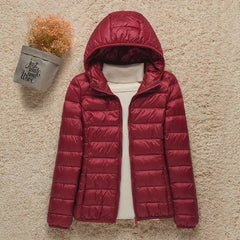 Women's lightweight hooded quilted jacket by Christine Brewer, packable puffer style with a cozy hood and quilted design.