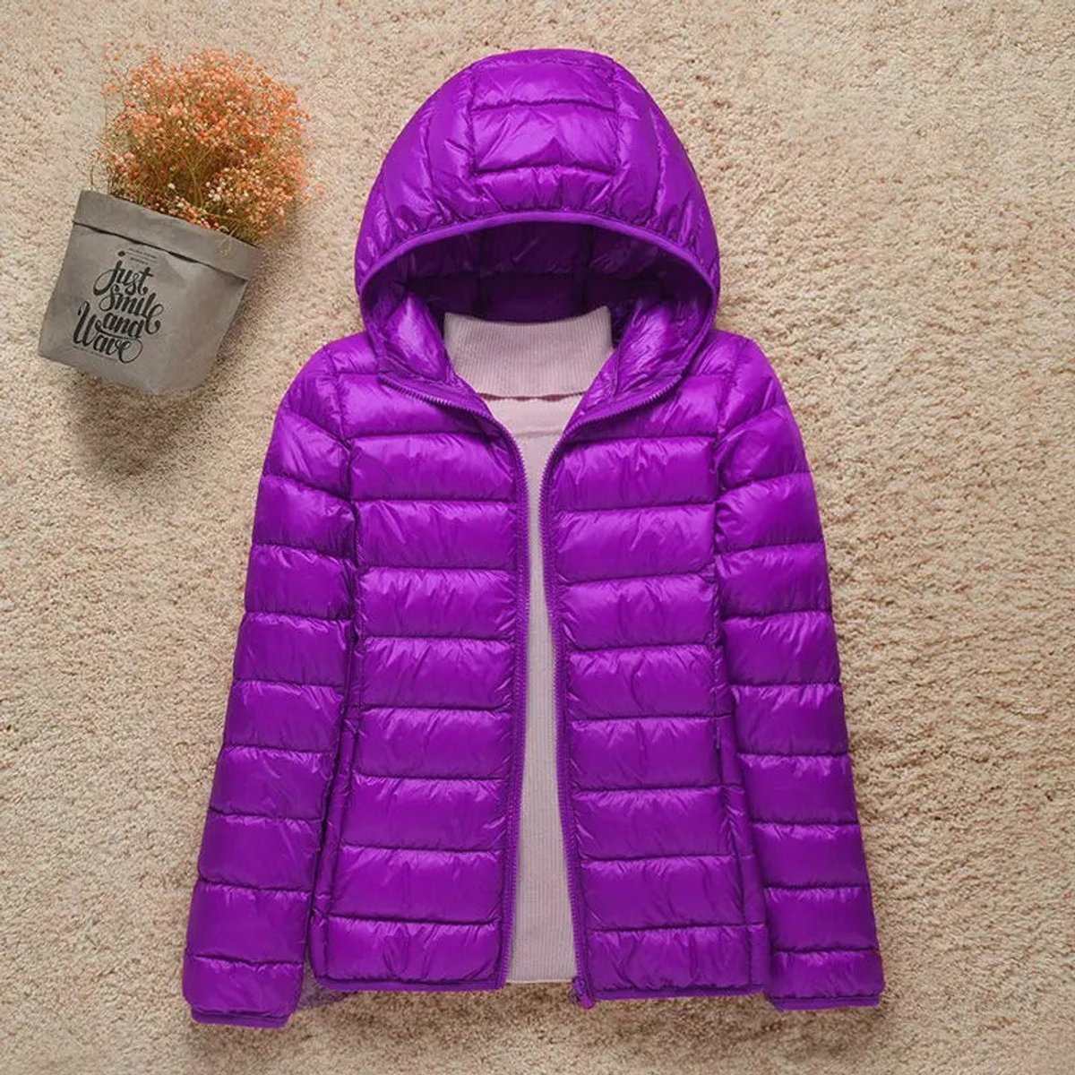 Woman wearing Christine Brewer Eleanor lightweight hooded quilted puffer jacket, showcasing its packable, insulated design.