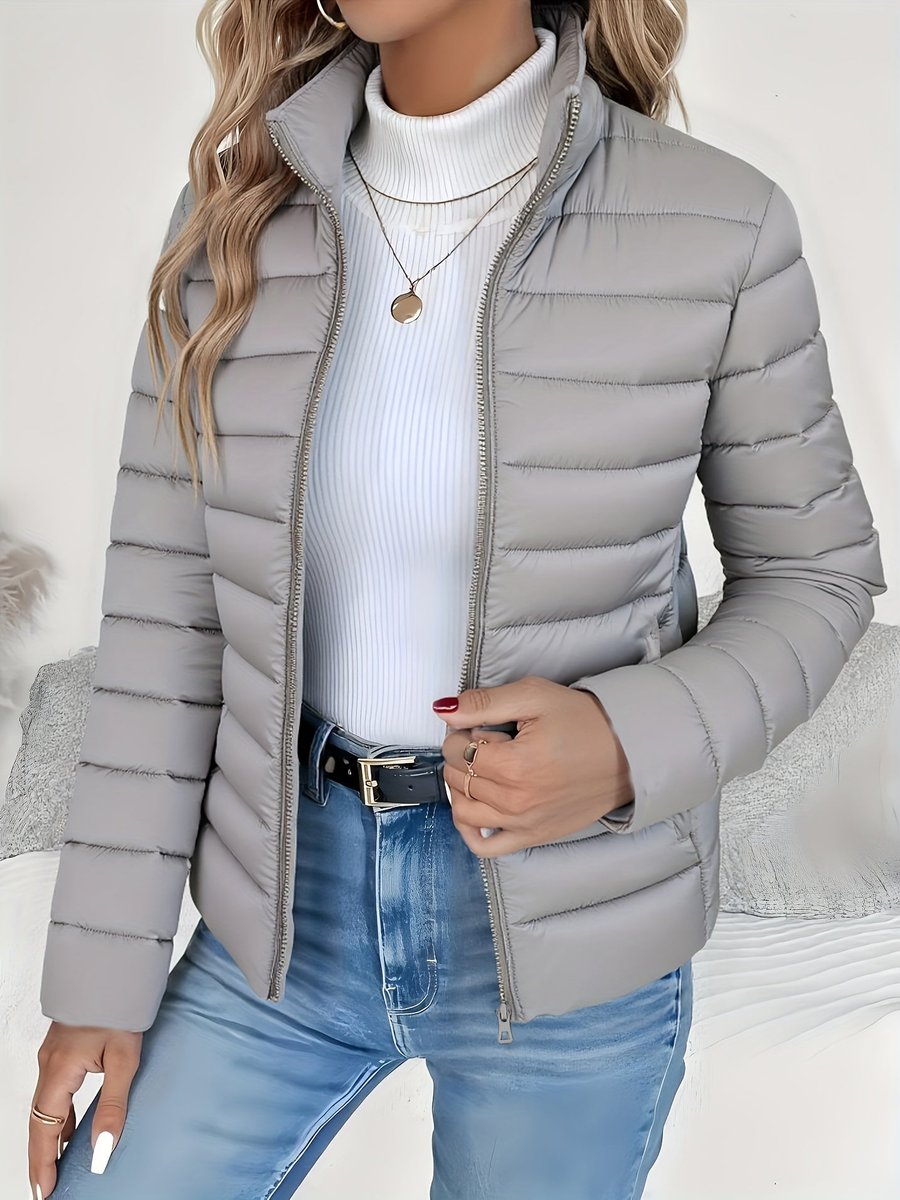 Women's lightweight quilted puffer coat with stand collar and zip-up front, designed by Christine Brewer.