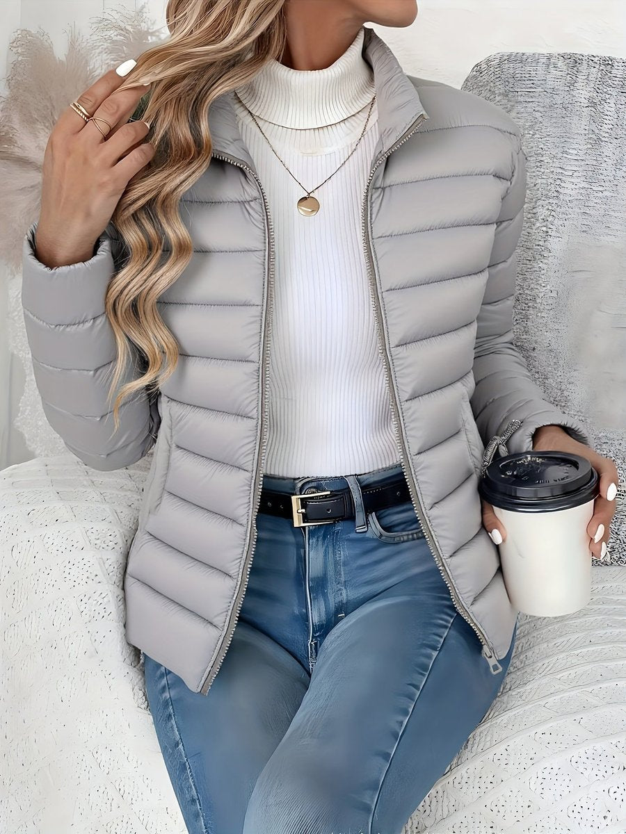Women's lightweight quilted puffer coat by Christine Brewer with stand collar and front zip-up closure.